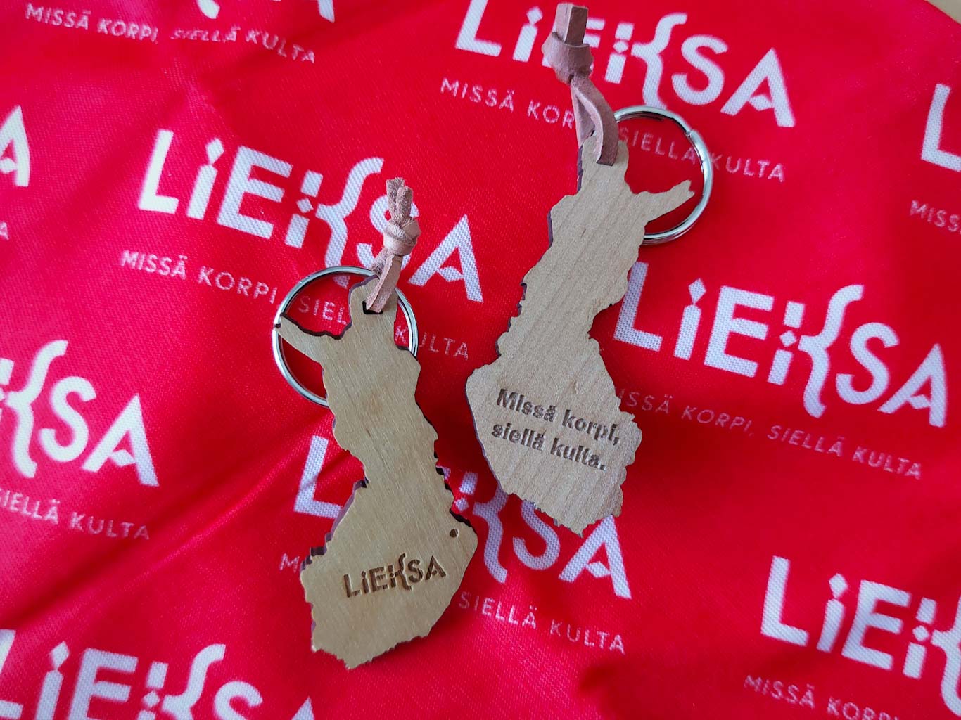 Puisia Lieksa-avaimenperiä punaisen kankaan päällä