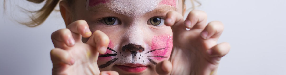 Kissaa esittävä lapsi, jolla on kasvomaalauksia