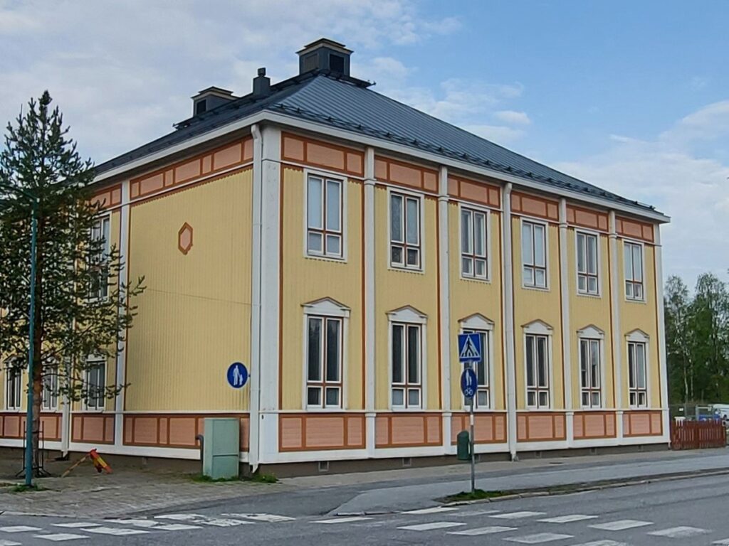 Vanha, kunnostettu kaksikerroksinen puukoulu. Rakennuksessa on korkeat ruutuikkunat.