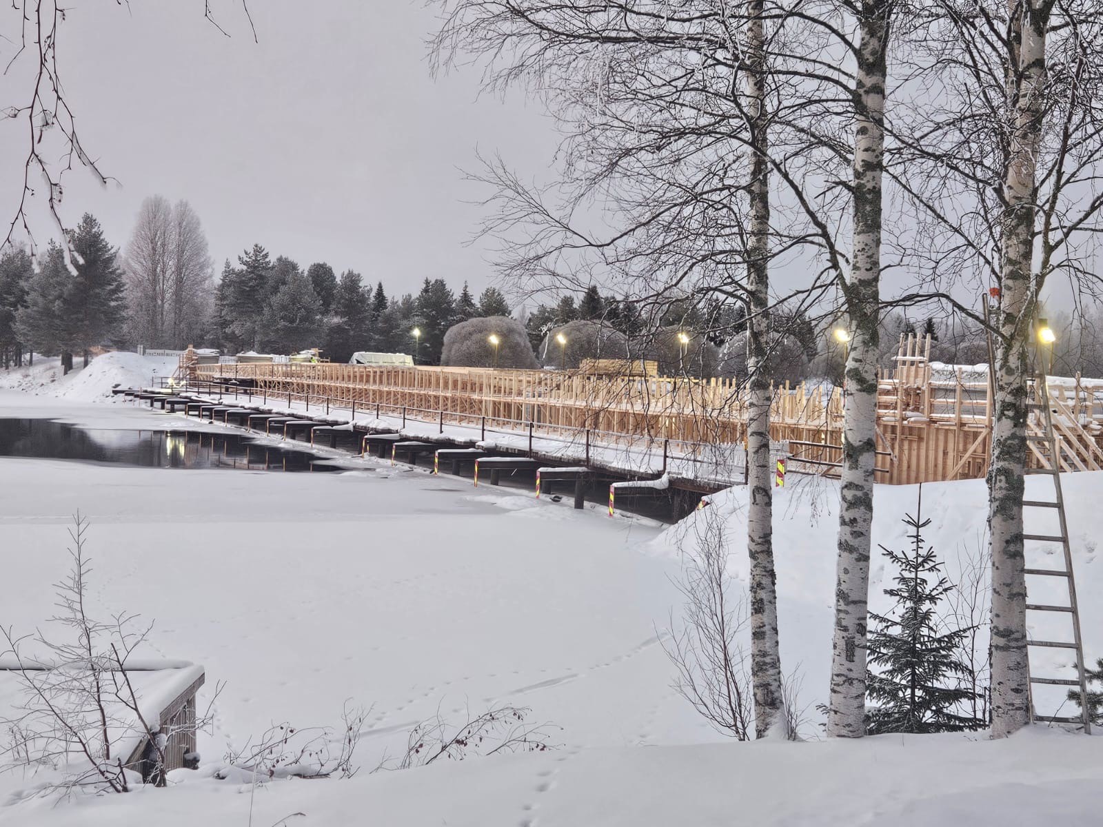 Betonimuotit siltatyömaalla. Talvi, lunta maassa ja joki osin jäätynyt.