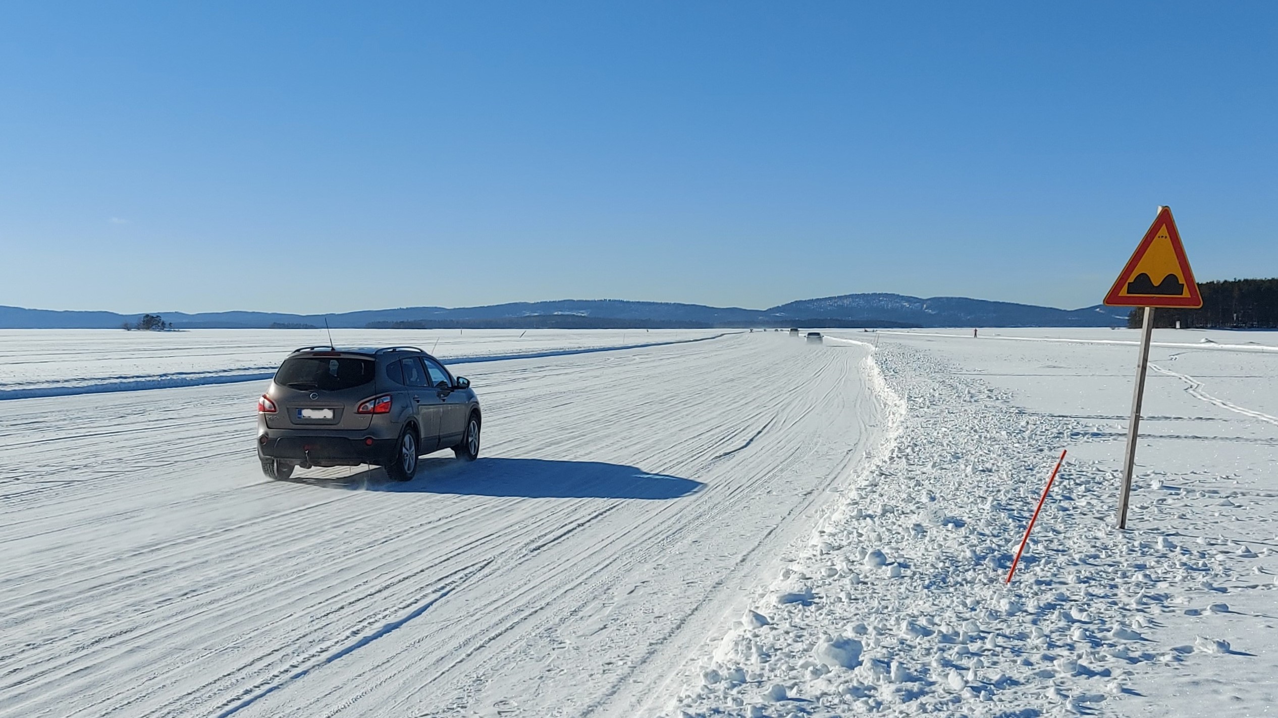 Auto jäätiellä. Kauempana jäällä näkyy kaksi muutakin autoa.