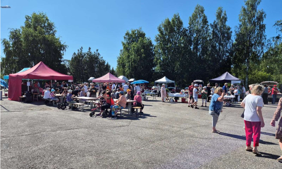 Ihmisiä torilla. Myyntitelttoja.